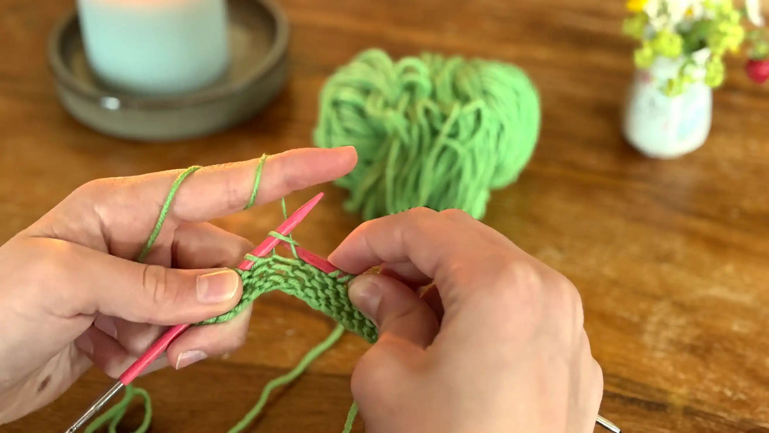 Hände eines Anfängers beim Stricken